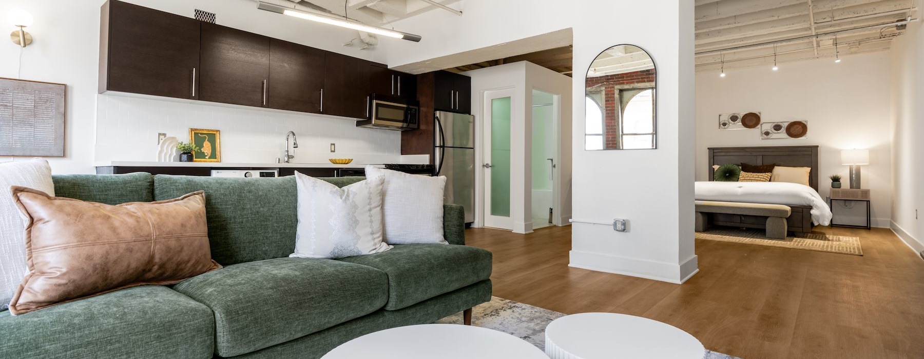 a studio apartment with a couch, a bed and a kitchen