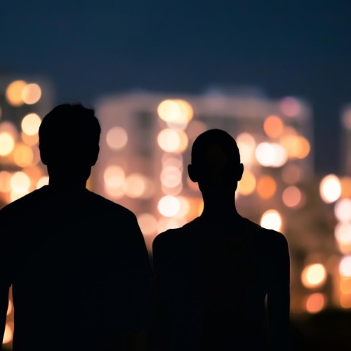 The essence of exceptional living a man and a woman looking at a city at night