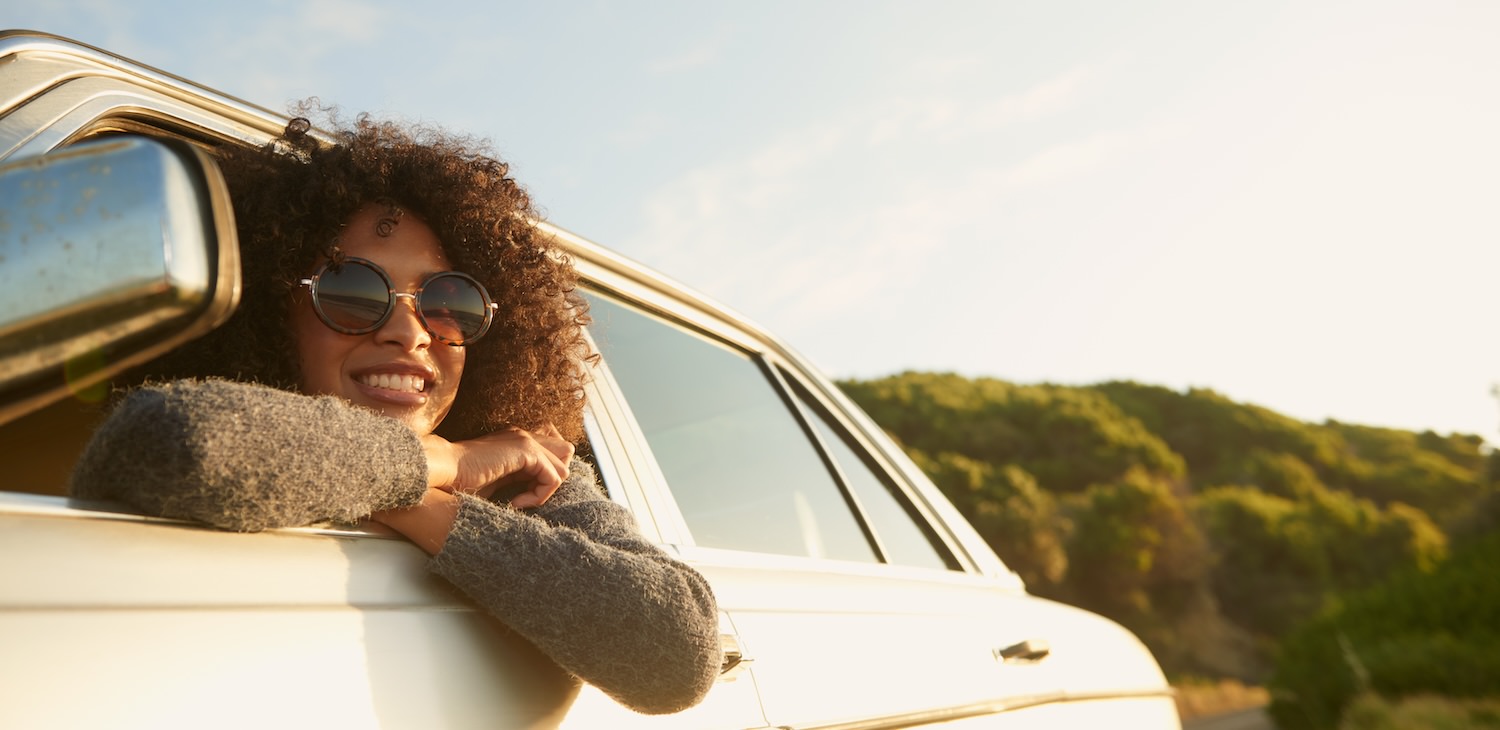The essence of exceptional living a woman leaning out of a car smiling